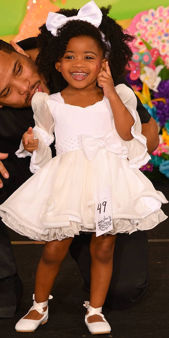 Rylie joined the competition — help win amazing prizes! beauty, child, day_dress, dress, event, facial_expression, fashion_accessory, fashion_design, flash_photography, formal_wear, fun, gesture, happy, headwear, human_leg, joy, one_piece_garment, person, pink, skin