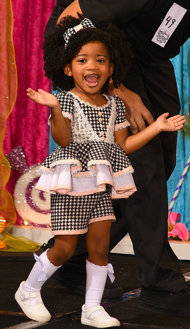 Rylie is registered to the contest to win money with this photo: child, costume, entertainment, event, fashion_design, fun, happy, hat, human_leg, joy, pattern, performance, performing_arts, person, pink, plaid, shoe, smile, sock, tartan