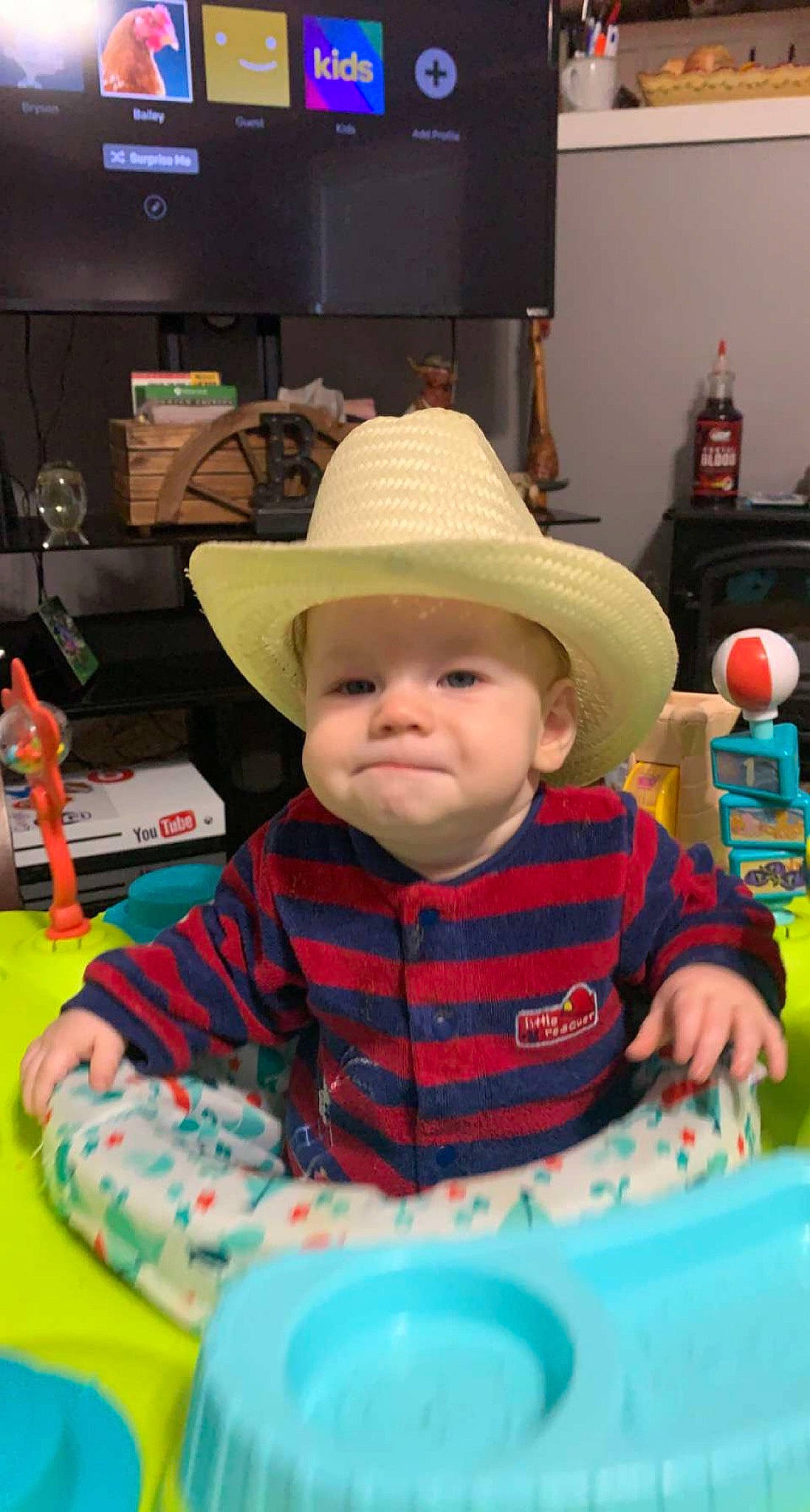 Kye is registered to the contest to win money with this photo: baby, baby_products, baby_toddler_clothing, cap, child, fashion_accessory, fun, happy, hat, headwear, leisure, person, play, product, room, sitting, smile, sun_hat, television, toddler