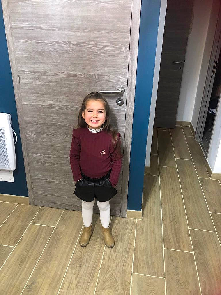 Sélène a rejoint le concours — aidez-le/la à gagner de superbes lots ! child, door, floor, flooring, fun, hairstyle, hardwood, human_leg, jacket, joy, laminate_flooring, leg, person, plank, smile, standing, thigh, toddler, varnish, wood