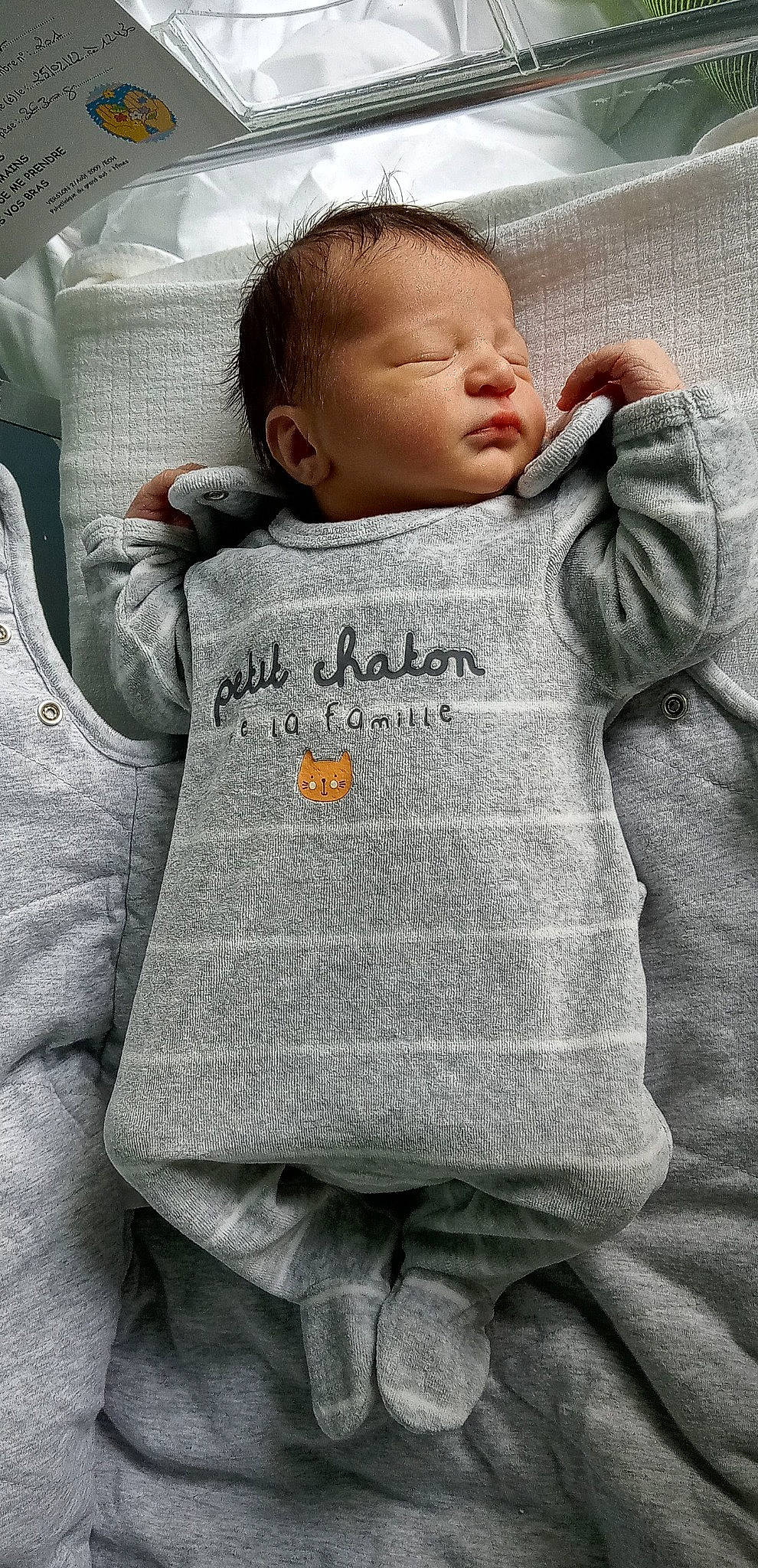 Loukas participe au concours pour gagner de l'argent avec cette photo : arm, baby, baby_toddler_clothing, cheek, chin, comfort, eye, face, facial_expression, hair, hairstyle, hand, head, joint, mouth, nose, outerwear, person, product, skin
