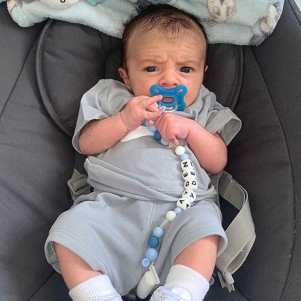 Ayden participe au concours pour gagner de l'argent avec cette photo : baby, baby_seat, child, clothing, comfort, cute, expression, face, footwear, gray_outfit, hand, indoor, infant, pacifier, plush_toys, seat, small, socks, toy, white_shoes