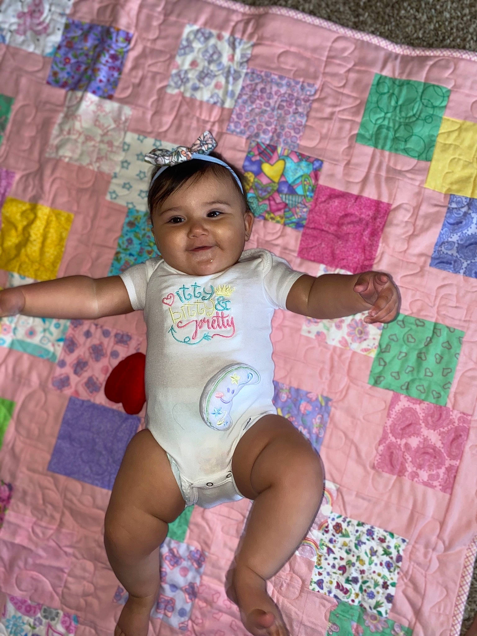 Nakiah is registered to the contest to win money with this photo: baby, baby_toddler_clothing, barefoot, blue, child, comfort, face, happy, human_leg, leg, linens, magenta, pattern, person, pink, product, purple, skin, textile, thigh