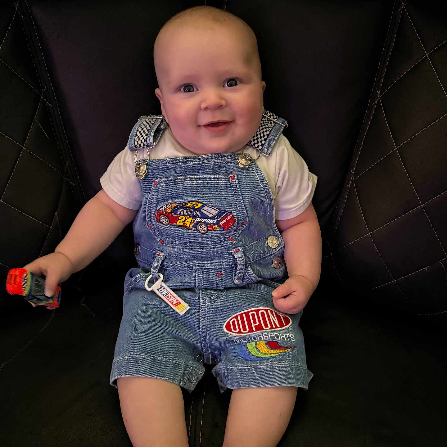 Bucklee joined the competition — help win amazing prizes! baby, bodypart, clothing, couch, face, finger, furniture, hand, happy, head, homedecor, jeans, pants, person, photography, portrait, shorts, sitting, smile, vest