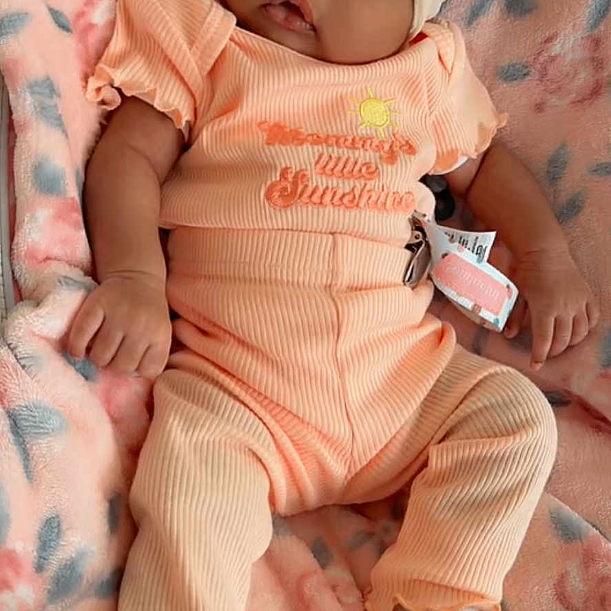 Jeriha joined the competition — help win amazing prizes! baby, infant, headband, bow, blanket, pink, orange_outfit, sitting, cute, portrait, child, soft_texture, cozy, indoors, newborn, fashion, clothing, face, expression, snapchat