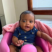 Jeriah joined the competition — help win amazing prizes! baby, child, infant, pink_seat, blanket, indoor, window, navy_onesie, bee_pattern, curious_expression, feet, hands, face, person, young_child, wooden_window_frame, soft_texture, comfortable, seated, bright_colors