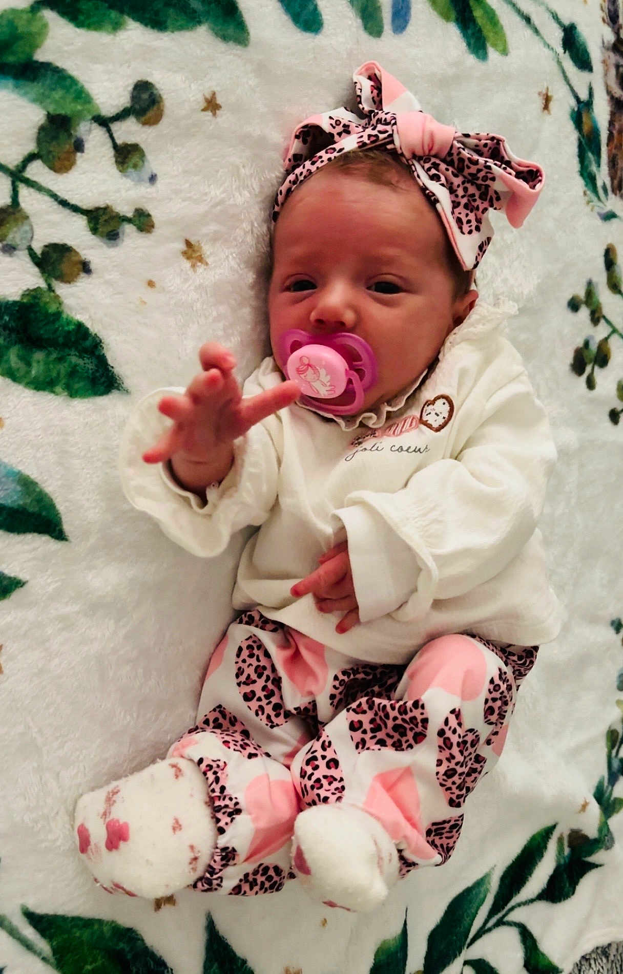Amaïa participe au concours pour gagner de l'argent avec cette photo : baby, infant, pacifier, headband, pink, white, leopard_print, clothing, socks, blanket, pattern, cute, hand, face, lying_down, soft_texture, indoor, child, newborn, adorable