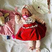 Amaïa a rejoint le concours — aidez-le/la à gagner de superbes lots ! baby, sleeping, pacifier, red_skirt, cat_print, head_wrap, plush_toy, blanket, soft_texture, pink, beige, toddler, clothing, cute, infant, lying_down, cozy, child, toy, portrait