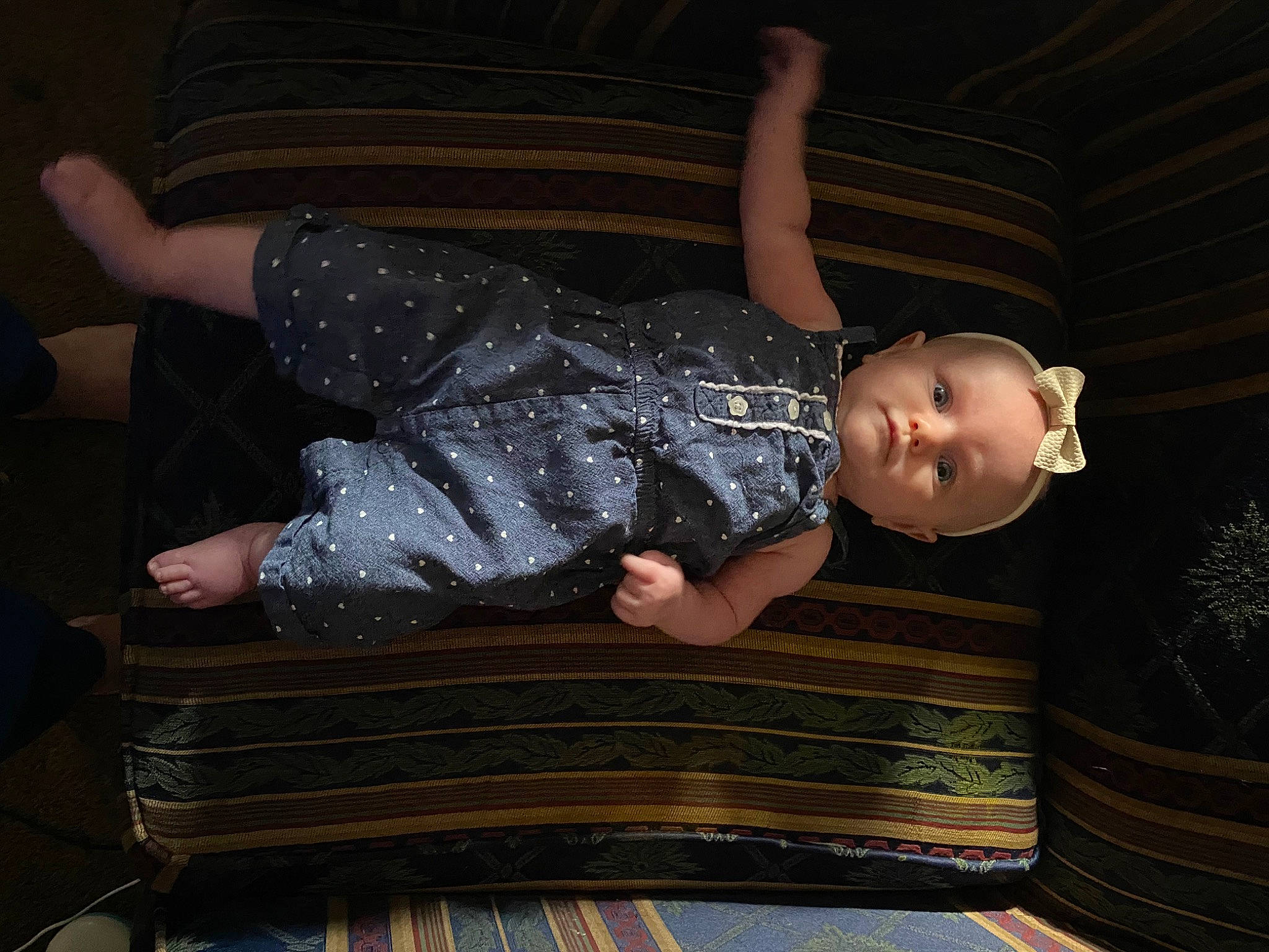 Emmaline is registered to the contest to win money with this photo: baby, baby_toddler_clothing, book, child, comfort, darkness, elbow, flash_photography, foot, fun, human_leg, knee, lap, pattern, person, room, sitting, thigh, toddler, wood