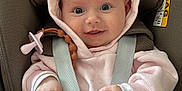 Francesca is registered to the contest to win money with this photo: baby, infant, car_seat, maxi_cosi, pink_clothing, hoodie, pacifier, baby_strap, smiling, wide_eyes, cute, cozy, child, seatbelt, safety, indoor, portrait, happy, hands, soft_texture