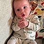 Francesca is registered to the contest to win money with this photo: baby, infant, onesie, caterpillar_print, couch, cushion, floral_pattern, bird_pattern, clothing, hands, face, wide_eyes, expression, indoor, soft_lighting, seated, cute, child, portrait, cozy