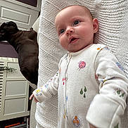 Francesca joined the competition — help win amazing prizes! baby, infant, onesie, blanket, knitted, drool, dog, pet, indoor, home, furniture, curious, lying_down, white, patterned_clothing, face, head, cute, comfort, relaxed