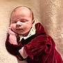 baby, sleeping, infant, blanket, soft_texture, burgundy_clothing, white_collar, peaceful, portrait, closeup, newborn, cute, child, resting, cozy, warm, indoors, skin, face, hand