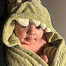 Graysen is registered to the contest to win money with this photo: baby, child, chubby_cheeks, clothing, cozy, cute, cute_outfit, dinosaur, expression, eyes, face, green, hood, indoors, infant, portrait, skin, soft_lighting, towel, wrapped