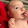 Graysen is registered to the contest to win money with this photo: baby, child, closeup, curious, cute, expression, eyes, face, fingers, hand, head, indoors, infant, mouth, newborn, person, portrait, red_clothing, skin, skin_texture