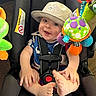baby, child, car_seat, hat, smile, toy, colorful, indoors, seatbelt, infant, playful, foot, hand, happy, closeup, cute, childrens_toy, soft_toy, fabric, portrait