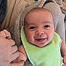 baby, baby_bottle, bib, blanket, bottle, child, clothing, cute, face, finger, hand, happy, holding_hand, indoor, infant, newborn, person, portrait, skin, smile