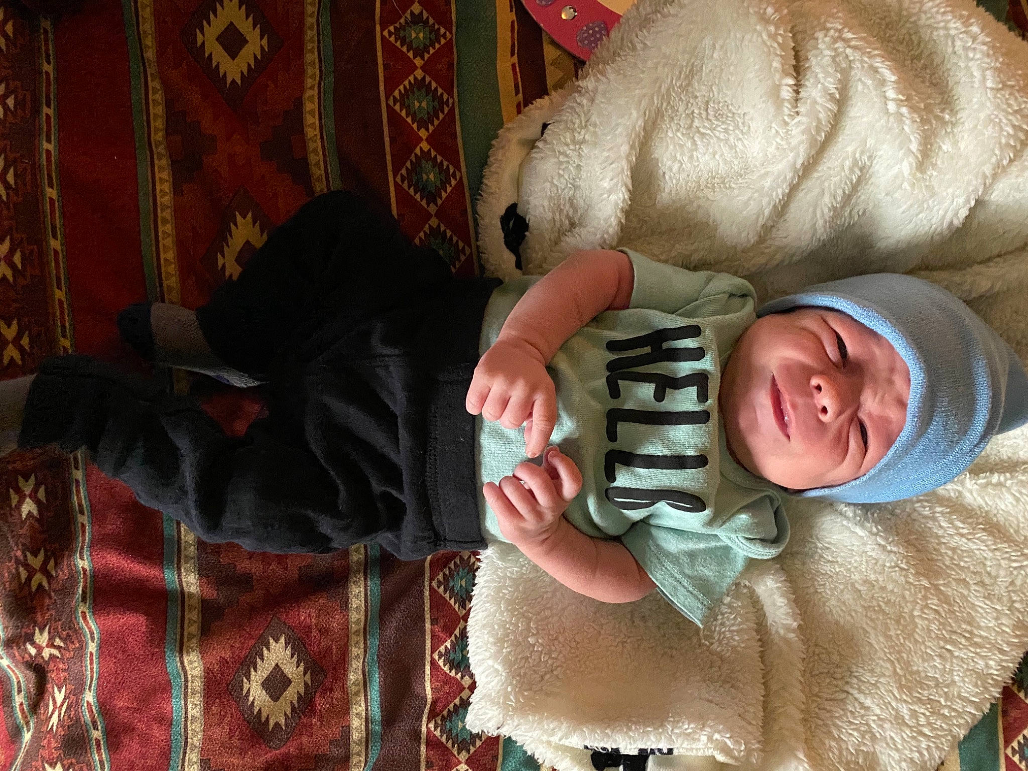 Sullivan is registered to the contest to win money with this photo: baby, baby_products, baby_toddler_clothing, cheek, child, comfort, curtain, eye, fur, hand, headwear, human_body, linens, mouth, pattern, person, plaid, room, skin, tartan