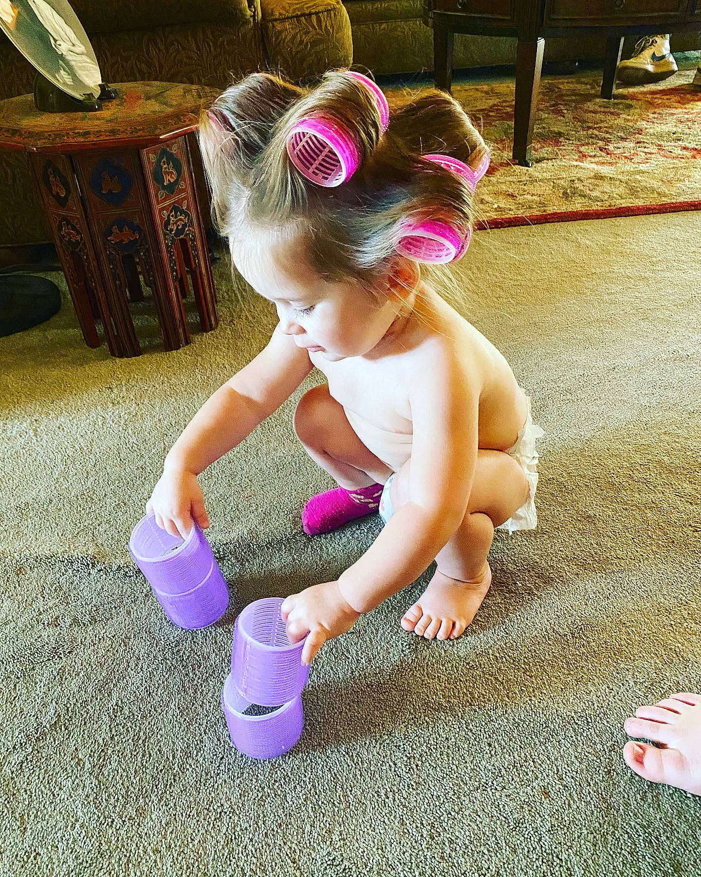 Fenner is registered to the contest to win money with this photo: baby, baby_toddler_clothing, barefoot, child, foot, fun, grass, happy, headband, headpiece, human_leg, leisure, magenta, person, pink, play, purple, sandal, sitting, sock