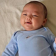 Léo a rejoint le concours — aidez-le/la à gagner de superbes lots ! baby, infant, onesie, blue_clothing, smile, chubby_cheeks, face, eyes, head, ear, lying_down, bed_sheet, blanket, indoor, portrait, closeup, soft_lighting, cute, happy, watermark