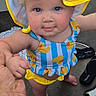 Ember is registered to the contest to win money with this photo: toddler, child, baby, swimsuit, sunhat, blue_eyes, hand_holding, boat, footwear, deck, summer, outdoor, cute, yellow, blue, clothing, person, standing, playful, smiling