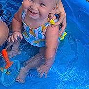 Ember is registered to the contest to win money with this photo: toddler, child, smiling, pool, water, swimsuit, toy, hand, blonde_hair, outdoor, summer, play, happy, cute, baby, sitting, blue, plastic_pool, nature, fun