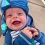 baby, child, smiling, blue_hat, striped_clothing, outdoor, happy, infant, sun_hat, closeup, face, hands, playful, cute, joyful, person, apparel, pattern, texture, light