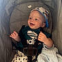 baby, smile, cap, adidas, stroller, blanket, child, clothing, happy, infant, seatbelt, person, infantwear, cute, relaxed, indoors, smallchild, fashion, comfort, expression