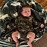 baby, sleeping, infant, blanket, camouflage_clothing, moose_pattern, cozy, indoors, wood_floor, diaper, cute, peaceful, child, newborn, soft_texture, resting, small_hands, small_feet, portrait, relaxation