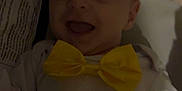 Atticus is registered to the contest to win money with this photo: baby, infant, bow_tie, smiling, happy, clothing, face, expression, indoors, portrait, child, cute, joy, apparel, closeup, person, newborn, cheerful, dark, fabric