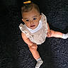 baby, child, infant, sitting, dress, ruffles, yellow_bow, socks, black_rug, curious, looking_up, cute, indoors, person, portrait, legs, hands, happy, soft_texture, casual_clothing