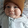 Corbin joined the competition — help win amazing prizes! baby, infant, face, hat, beanie, clothing, white_outfit, zipper, cute, smile, cheeks, bed, blanket, patterned_blanket, soft_texture, headwear, portrait, indoor, child, young