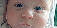 Corbin is registered to the contest to win money with this photo: baby, infant, face, blue_eyes, onesie, clothing, closeup, portrait, child, cute, soft, blanket, fabric, newborn, skin, head, expression, person, indoor, young