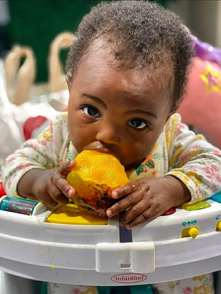 Malia is registered to the contest to win money with this photo: biting, child, cuisine, dish, facial_expression, food, food_craving, fruit, fun, happy, natural_foods, people, person, plant, produce, sharing, strawberry, sweetness, tableware, toddler