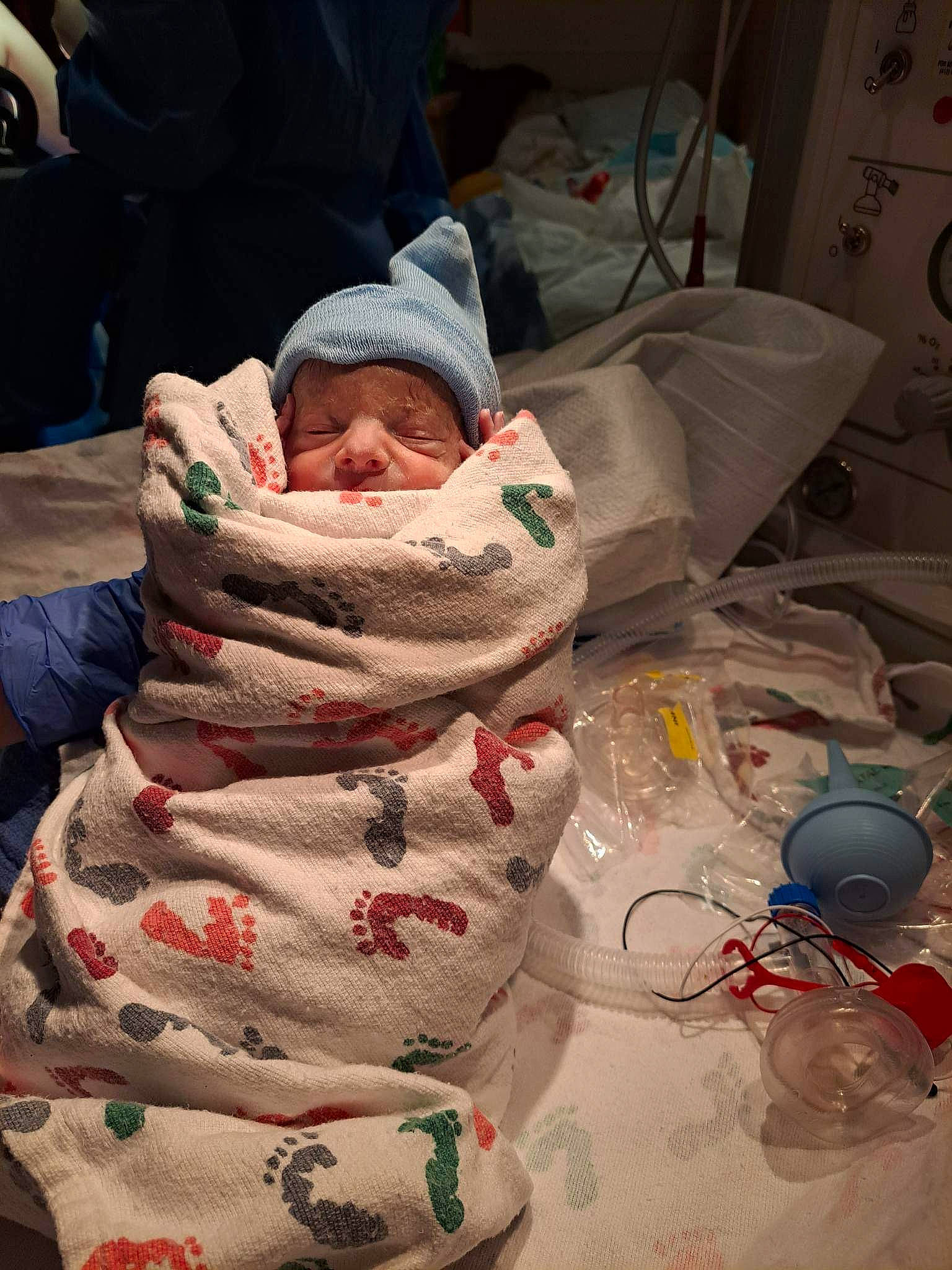 Ryker is registered to the contest to win money with this photo: baby, carmine, child, comfort, event, flesh, fun, hat, headwear, holiday, human_leg, lap, linens, pattern, person, plastic, room, santa_claus, sitting, textile