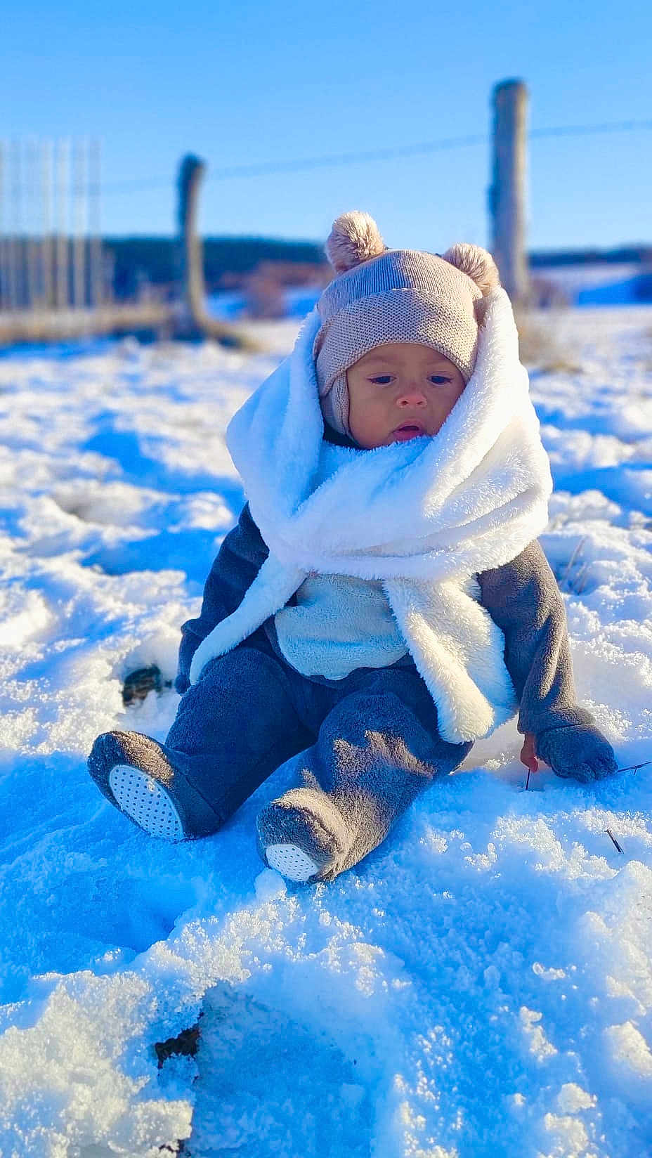 Thomas a rejoint le concours — aidez-le/la à gagner de superbes lots ! baby, child, snow, winter_clothing, hat, scarf, outdoor, blue_sky, cold, frozen, cute, sitting, warm_clothes, gloves, boots, nature, daytime, fur, scenery, portrait