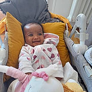 Jade a rejoint le concours — aidez-le/la à gagner de superbes lots ! baby, smiling, hoodie, hearts, cushion, pillow, stroller, plush_toy, indoor, child, cute, happy, cozy, fabric, soft_toys, infant, person, comfort, relaxation, casual