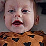 Aurora is registered to the contest to win money with this photo: baby, closeup, face, eyes, mouth, expression, infant, child, clothing, heart_pattern, cute, adorable, portrait, skin, head, young, person, happy, smiling, indoors