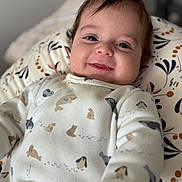 Nathan a rejoint le concours — aidez-le/la à gagner de superbes lots ! baby, infant, smiling, face, onesie, animal_print, cushion, patterned, lying_down, happy, closeup, child, cute, soft_lighting, indoors, portrait, young_child, cozy, expression, person