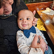 accessories, baby, bodypart, clothing, coat, couch, face, finger, furniture, hand, head, indoors, jacket, jewelry, person, photography, portrait, restaurant, ring, wood