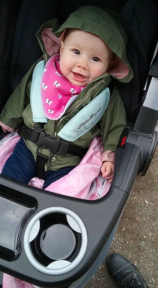 Cordelia is registered to the contest to win money with this photo: auto_part, baby, baby_carriage, baby_in_car_seat, baby_products, car_seat, child, daughter, person, pink, product, sitting, smile, toddler