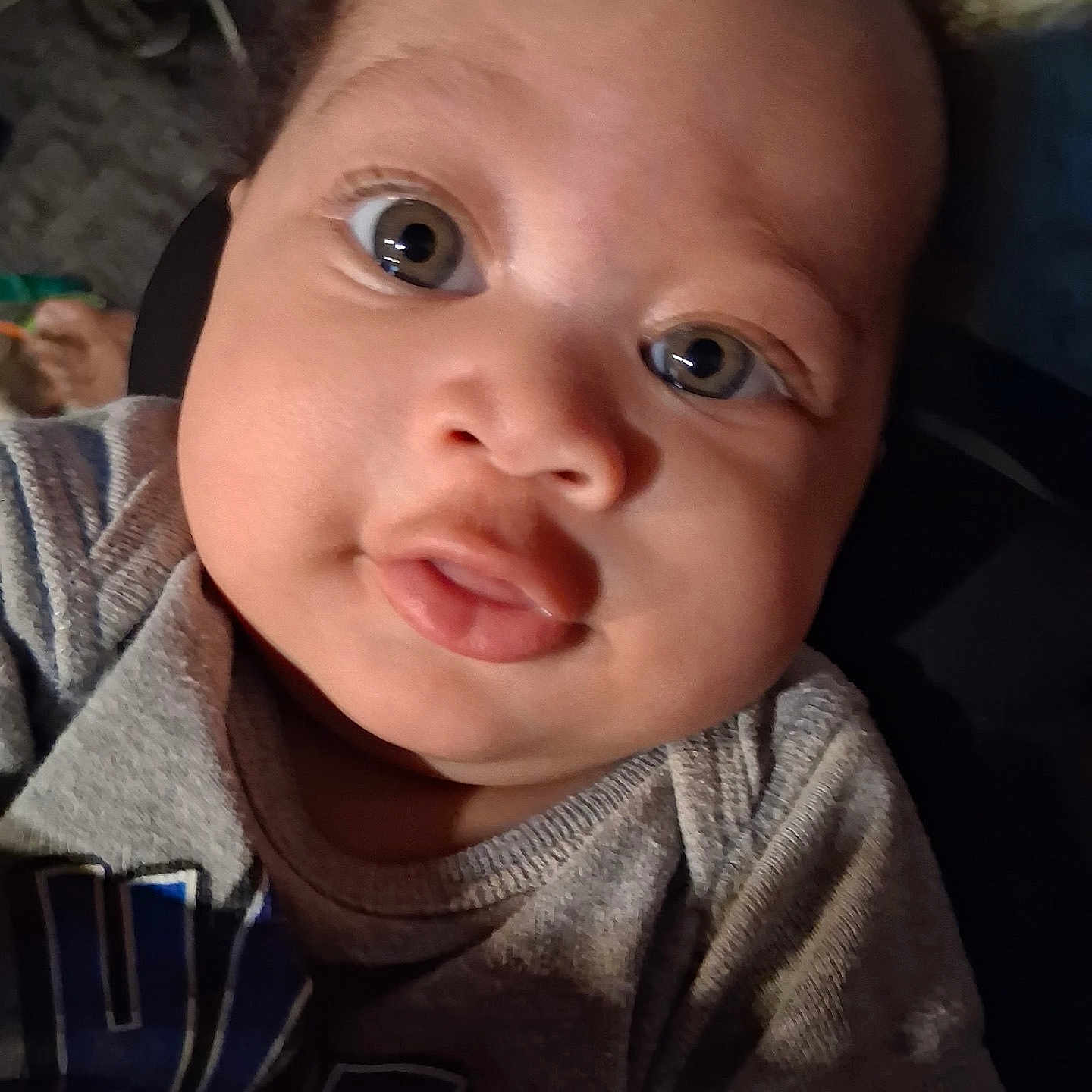 Jace is registered to the contest to win money with this photo: baby, face, child, portrait, eyes, expression, curious, chubby_cheeks, clothing, grey_shirt, indoor, closeup, person, infant, cute, head, skin, young, looking, human