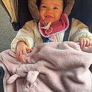 Joy participe au concours pour gagner de l'argent avec cette photo : baby, infant, stroller, blanket, pacifier, hood, smile, happy, pink, cozy, cute, winter_coat, bib, hands, portrait, canopy, fabric, plush, seatbelt, outdoor_pavement