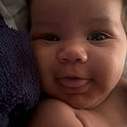 Talayah is registered to the contest to win money with this photo: baby, blanket, child, close_up, cuddle, curly_hair, cute, expression, face, happy, indoors, infant, person, portrait, skin, smiling, soft_light, tongue_out, towel, young