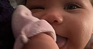 Talayah is registered to the contest to win money with this photo: baby, blanket, child, close_up, curly_hair, cute, expression, face, hand, indoors, infant, mitten, person, playful, skin, smile, soft, tongue, warm, young