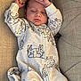 Leo is registered to the contest to win money with this photo: baby, infant, newborn, onesie, pajamas, couch, sofa, blanket, sleepy, face, head, arm, hand, animal_print, pattern, fabric, textile, indoor, portrait, resting