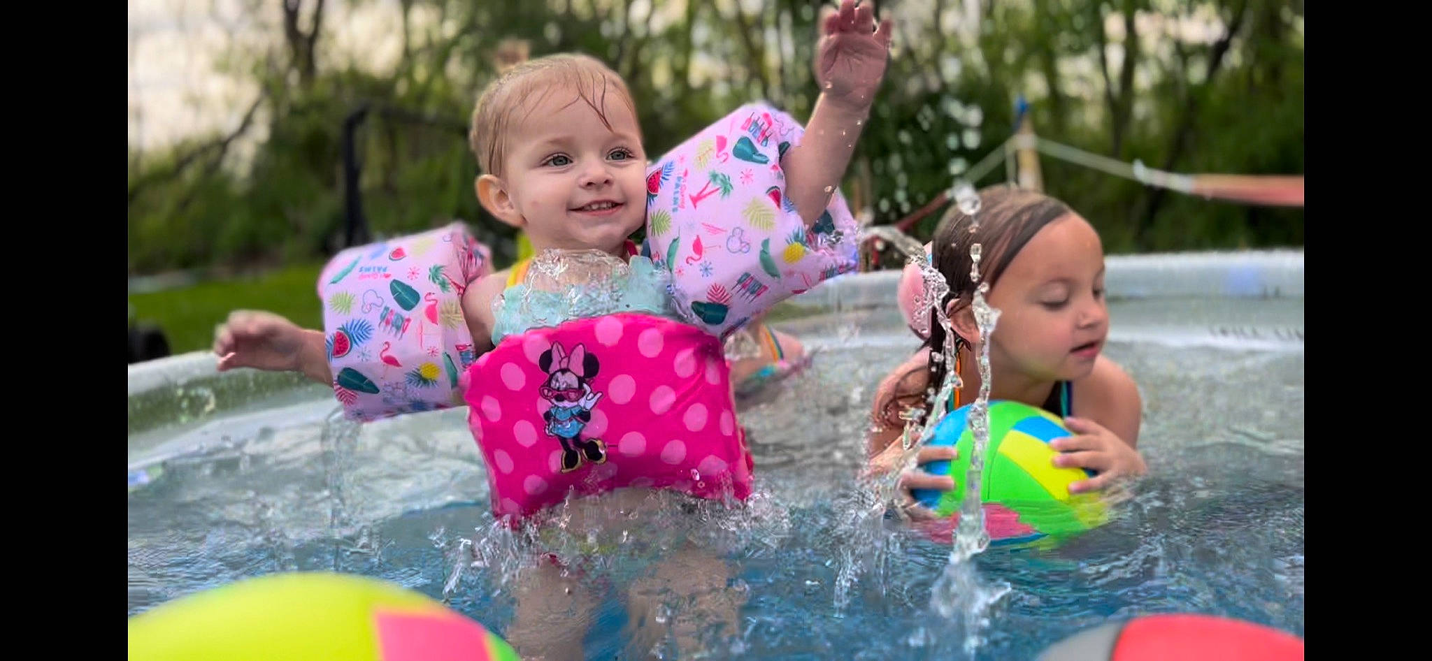 Kya joined the competition — help win amazing prizes! baby_toddler_clothing, face, fun, grass, happy, human_settlement, joy, leisure, outdoor_recreation, person, personal_protective_equipment, pink, public_space, recreation, smile, summer, swimwear, toddler, tree, vertebrate