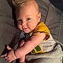 baby, child, infant, smile, face, arm, blanket, shirt, blue_eyes, mohawk_hairstyle, lying_down, cozy, soft, cute, indoors, person, skin, happy, toddler, portrait