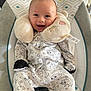 baby, smile, onesie, plush, baby_chair, cushion, happy, infant, face, comfort, sleeping_pillow, pattern, clothing, cute, child, indoors, soft_toy, relaxation, small_person, seated
