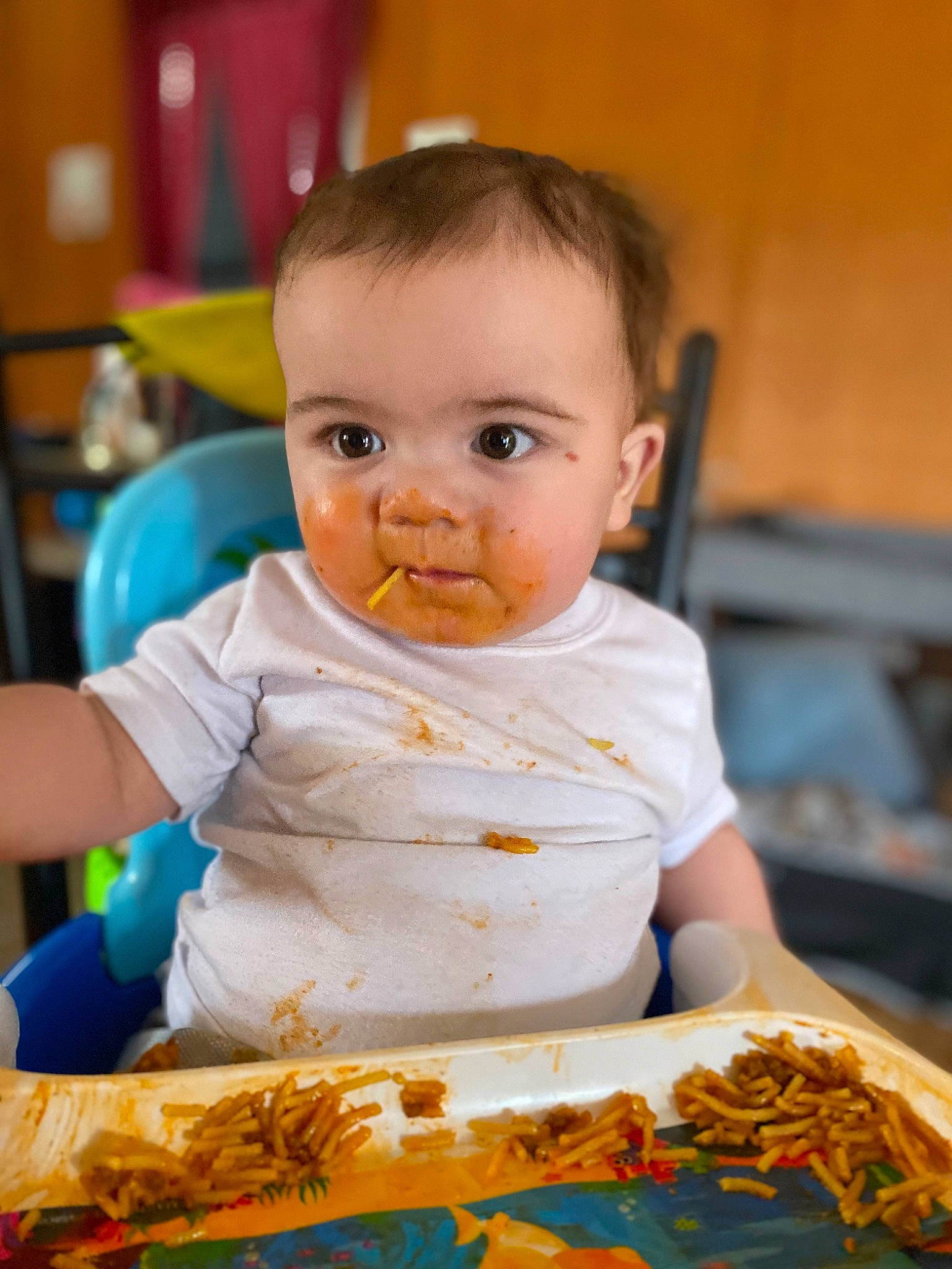 Amias is registered to the contest to win money with this photo: baby, baby_toddler_clothing, chair, cheek, child, comfort_food, cuisine, eating, event, food_craving, fun, happy, iris, leisure, orange, person, room, sitting, sweetness, t_shirt